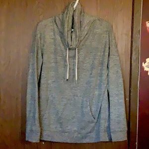 Light grey sweater with loose turtle neck and big front pocket.